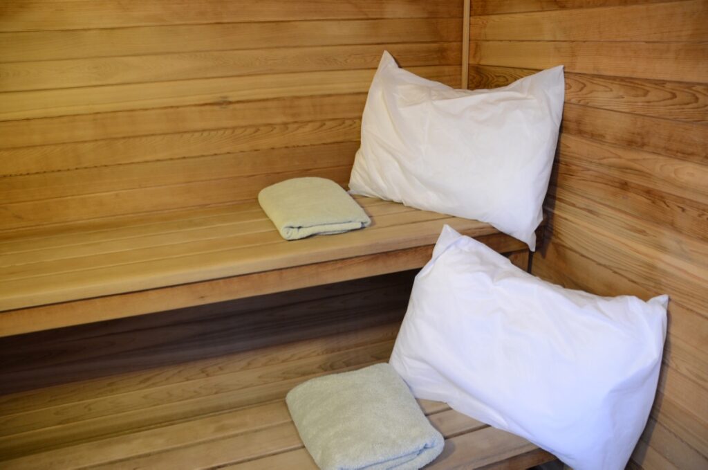 Wooden sauna benches with pillows and towels at Spaah