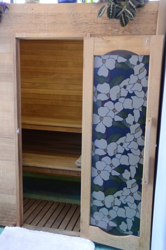 Entrance to the Spaah sauna with a stained-glass dogwood door